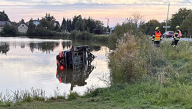 Řidič špatně zapojil tažné zařízení, přívěs s naloženým autem utopil v rybníku